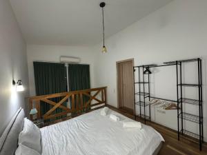 1 dormitorio con cama blanca y puerta verde en Cosmo LOFT #pool, en Ştefăneştii de Sus