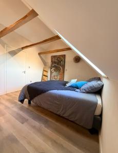 Un dormitorio con una cama en un ático en Les Terrasses de MAJORAC - Le Boudoir, en Bozouls