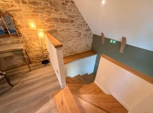 Habitación con escalera, mesa y pared de ladrillo. en Les Terrasses de MAJORAC - Le Boudoir, en Bozouls