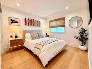 een slaapkamer met een groot bed en een spiegel bij Luxury Ocean View Rooftop - Steps to Beach & Pier in Newport Beach