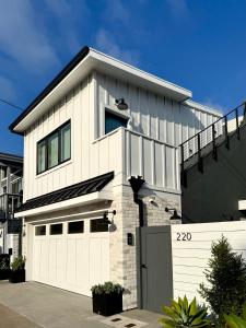 a white house with a garage at Luxury Ocean View Rooftop - Steps to Beach & Pier - Cool AC in Newport Beach