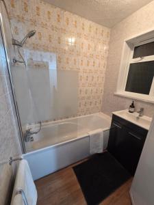 a bathroom with a tub and a sink at Edgware, Haru Residence 4bed House in Wealdstone