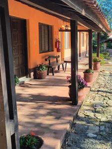 une véranda d'un bâtiment orange avec une table de pique-nique dans l'établissement Pousada LA VIVIAN, à Serra Negra