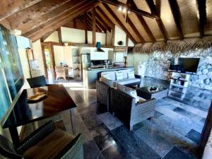 Una sala de estar con una mesa y una cocina. en Aitutaki Escape, en Arutanga