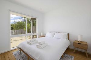 a bedroom with a white bed with two towels on it at Peaceful 2-Bed Apartment in Coastal McCrae in McCrae +4 photos