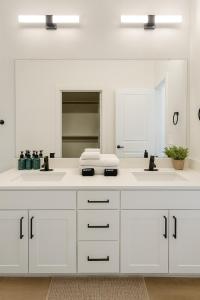 une salle de bain avec deux lavabos et un grand miroir dans l'établissement Cozy & Chic - Worker Friendly, à Sherman