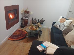 a living room with a couch and a table and a fireplace at O Caminho Azul in Olivenza +29 photos