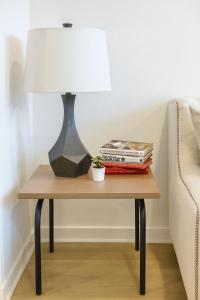 a table with a lamp and books on it at Cozy apartment by Pecan Park Texoma Med & More in Sherman