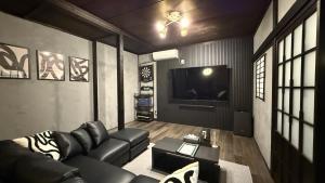 a living room with a couch and a tv at 一棟貸し宿 maicca1 in Numazu