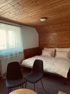 une chambre avec un lit avec deux chaises et une fenêtre dans l'établissement Wellness Hotel Zdobnice, à Zdobnice