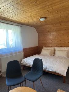 une chambre avec un lit et deux chaises bleues dans l'établissement Wellness Hotel Zdobnice, à Zdobnice