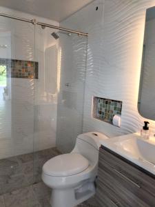 une salle de bains blanche avec toilettes et lavabo dans l'établissement Villa Liam Casa Turística, à Prado