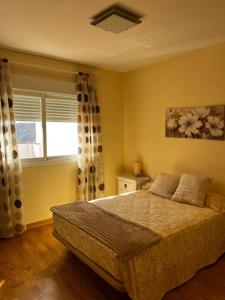 een slaapkamer met een bed en een raam bij Apartamento vital centrico in Lanjarón