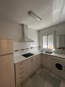 een witte keuken met een wastafel en een koelkast bij Apartamento vital centrico in Lanjarón