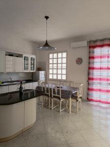 a kitchen with a table and chairs and a kitchen with a window at AleMar House in Marinella di Selinunte +9 photos