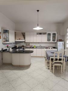 a kitchen with white cabinets and a table with chairs at AleMar House in Marinella di Selinunte