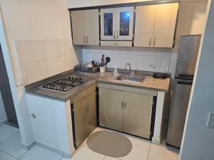 eine kleine Küche mit Herd und Spüle in der Unterkunft Apartamento Galanni 201 - Mirador del Valle in Valledupar + 34 Fotos