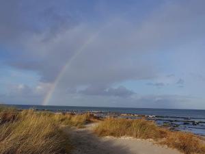 a rainbow over the ocean with a beach with a rainbow at 9 person holiday home in Jerup-By Traum in Jerup