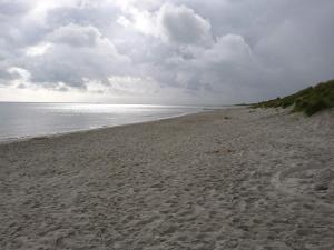 a sandy beach with a cloudy sky and the ocean at 9 person holiday home in Jerup-By Traum in Jerup