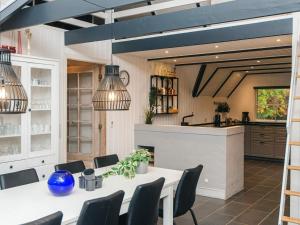 ブラーバンドにあるLuxury Retreat in Blavand - By Traum Ferienwohnungenのテーブルと椅子のあるキッチンとダイニングルーム