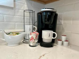 eine Theke mit Tassen und einer Kaffeemaschine in der Unterkunft Gorgeous loft downtownSherman washer dryer WiFi in Sherman