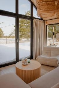 a living room with a coffee table and large windows at Ulinia Harmony Hill in Ulinia