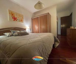 a bedroom with a large bed with a wooden headboard at Quiaios Beach House in Quiaios +11 photos