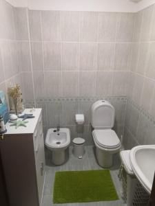 a bathroom with a white toilet and a sink at Quiaios Beach House in Quiaios