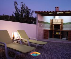 a group of chairs sitting on a patio with a fireplace at Quiaios Beach House in Quiaios