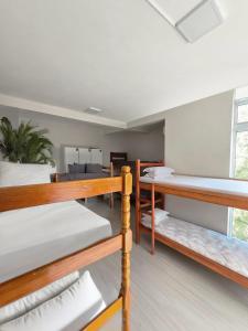 Habitación con 3 literas y sofá en Foresthouse Beach Hostel, en Florianópolis