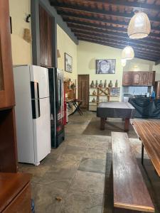 ein Wohnzimmer mit einem Kühlschrank und einem Tisch in der Unterkunft Casa Atina - Atins in Atins