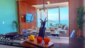 eine Küche mit Herd und einem Tisch mit Speisen und Getränken in der Unterkunft Condominios de lujo en el corazón de la Zona Dorada en Camino Al Mar. in Mazatlán