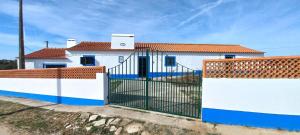 una casa bianca con un cancello davanti di Monte Velho do Pinheiro a São Cristóvão