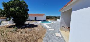 un cortile con una piscina e un albero accanto a una casa di Monte Velho do Pinheiro a São Cristóvão