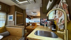 a kitchen with a sink and a living room at Australian Retro Beach stay in Rye