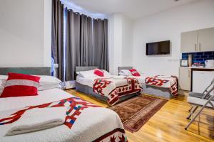 um quarto de hotel com duas camas e uma televisão em London Residence Hotel em Londres