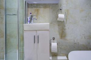 um banheiro com pia e chuveiro em London Residence Hotel em Londres