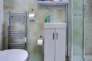 um banheiro com vaso sanitário, pia e chuveiro em London Residence Hotel em Londres mais 14 fotografias