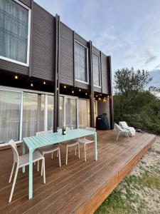 a house with a blue table and chairs on a deck at The Retreat at St Andrews Beach Golf Course in Fingal