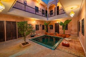 a swimming pool in a house with a tree in it at Riad Lalla Fatima Marrakech in Marrakesh