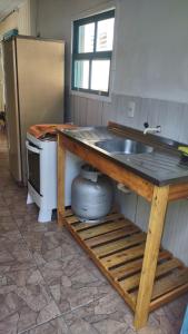 a kitchen with a sink and a refrigerator at Casa de Boneca perto da praia in Imbituba