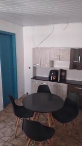 a kitchen with a table and chairs and a counter at Casa de Boneca perto da praia in Imbituba