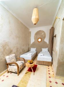 a room with two beds and a couch and a table at Riad Lalla Fatima Marrakech in Marrakesh