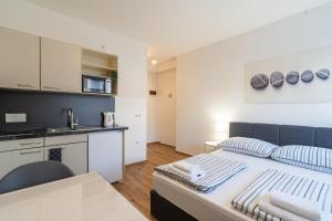 Un pequeño dormitorio con una cama y una cocina. en Alps Studio, en Innsbruck