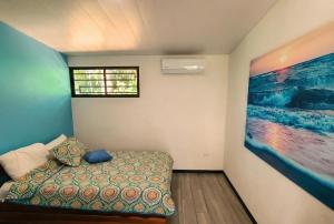 Una habitación con una cama y un cuadro en la pared. en Pura Vida - Villa Elenita, en Parrita 22 fotos más