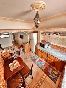 eine Küche mit einem Tisch und einem Kühlschrank in der Unterkunft Tayafut Apartments & Terrace by Surfleft Morocco in Mirleft + 40 Fotos
