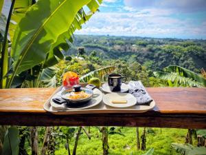 a tray of food sitting on a wooden table with a view at Hotel Cabañas Del Quindio in Filandia