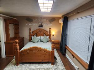 ein Schlafzimmer mit einem Bett und einem Schild an der Wand in der Unterkunft The Leafy Green Country Studio in Mount Vernon