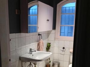 a bathroom with a sink and two windows at 566 Hostel in La Serena +36 photos