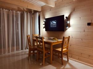 a dining room with a table and chairs and a television at Domki Michelle in Wisła